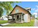 A side view of a two-story home showcasing a covered front porch, yard, and charming architectural details at 31 S Hinman St, Columbus, IN 47201