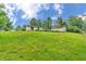 Wide view of the house showing the well-manicured lawn and exterior buildings at 3201 Chamberlin Dr, Indianapolis, IN 46227