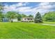 Home exterior with a lush lawn, driveway, garage, shed and beautiful landscaping at 3201 Chamberlin Dr, Indianapolis, IN 46227