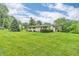 Wide view of home exterior featuring a well-manicured lawn and a beautiful mature tree at 3201 Chamberlin Dr, Indianapolis, IN 46227
