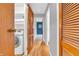 Bright hallway with hardwood floors, leading to a laundry area and a stylish blue accent wall at 3201 Chamberlin Dr, Indianapolis, IN 46227