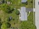 Aerial view reveals the property's roof, a sprawling yard with mature trees, and a patio with outdoor seating at 321 4Th E Ct, Carmel, IN 46033