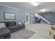 Finished basement featuring a gray sectional sofa, stairs to upper level, and neutral colors at 321 4Th E Ct, Carmel, IN 46033