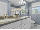 Modern bathroom features double sinks, vanity, large mirror, updated lighting, and a window with a view at 321 4Th E Ct, Carmel, IN 46033