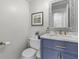 Chic half bathroom features a marble countertop, blue vanity, modern fixtures, and decorative mirror at 321 4Th E Ct, Carmel, IN 46033