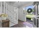 Bright foyer with hardwood floors, white staircase, and open front door at 321 4Th E Ct, Carmel, IN 46033