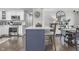 Bright kitchen showcasing a large island with seating, white cabinets, stainless steel appliances, and hardwood floors at 321 4Th E Ct, Carmel, IN 46033