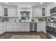 Modern kitchen featuring white cabinets, stainless steel appliances, and stylish lighting, creating a welcoming atmosphere at 321 4Th E Ct, Carmel, IN 46033