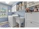 Functional laundry room featuring a washer, dryer, utility sink, storage cabinets, and a bright window at 321 4Th E Ct, Carmel, IN 46033