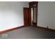 Bedroom featuring neutral carpet, wood trim, and open doorway at 340 W 11Th St, Anderson, IN 46016