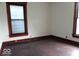 Bedroom with dark wood trim, hardwood flooring, and windows at 340 W 11Th St, Anderson, IN 46016