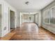 Hardwood-floored living room featuring multiple windows and entryways at 3526 E Vermont St, Indianapolis, IN 46201