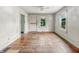Living room with hardwood floors, two windows and side entry door at 3526 E Vermont St, Indianapolis, IN 46201