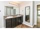 Well-lit bathroom featuring double sinks, dark cabinetry, and a full-length mirror at 4650 Blue Marlin Way, Indianapolis, IN 46239