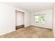 Carpeted living area with bright window and view of the home's hardwood floors at 4650 Blue Marlin Way, Indianapolis, IN 46239