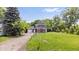 Charming two-story home with vertical siding, garage, and a long driveway, surrounded by mature trees and landscaping at 541 Dayton Ave, Indianapolis, IN 46203