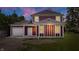 Charming two-story home with a classic design, featuring a detached garage and well-lit exterior against a lovely sky at 541 Dayton Ave, Indianapolis, IN 46203