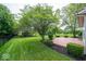 Expansive backyard featuring a wooden deck, lush lawn, mature trees, and an iron fence at 5883 Sandalwood Dr, Carmel, IN 46033