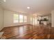 Open-concept living area with hardwood floors connecting to kitchen at 5883 Sandalwood Dr, Carmel, IN 46033