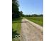 Scenic gravel driveway winding through a green field, offering a serene countryside view at 622 S Washington St, Morristown, IN 46161