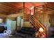 Living room with wood-paneled walls and ceilings, with stairs, couch, and kitchen in the background at 622 S Washington St, Morristown, IN 46161