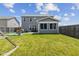 View of home with large, green backyard with playground equipment, gray siding, and screened porch at 632 Albermarle Dr, Pittsboro, IN 46167