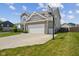 View of the side of the house with a driveway and basketball hoop attached to the garage at 632 Albermarle Dr, Pittsboro, IN 46167