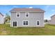 Backyard view showcasing the home's siding, windows, and a grassy area at 6507 W Whispering Way, Greenfield, IN 46140