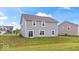 Backyard view showcasing the home's siding, windows, and a grassy area at 6507 W Whispering Way, Greenfield, IN 46140