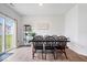 Open dining room with modern black dining table and sliding glass door to outdoor area at 6507 W Whispering Way, Greenfield, IN 46140