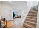 Bright entryway featuring hardwood floors, a staircase, and a view of the living room at 6507 W Whispering Way, Greenfield, IN 46140
