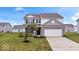 Charming two-story home with a well-manicured lawn and a two-car garage at 6507 W Whispering Way, Greenfield, IN 46140