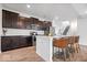 Modern kitchen featuring stainless steel appliances, a breakfast bar, and dark wood cabinetry at 6507 W Whispering Way, Greenfield, IN 46140
