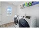 Bright laundry room features modern appliances, a large window, and convenient shelving for storage at 6507 W Whispering Way, Greenfield, IN 46140