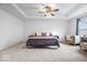 Bright main bedroom features tray ceilings, a window and seating, and light-colored carpet at 6507 W Whispering Way, Greenfield, IN 46140