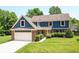 Charming two-story home showcasing a well-manicured lawn, brick accents and an attached two-car garage at 6580 Kings Ct, Avon, IN 46123
