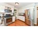 Beautiful kitchen features stainless steel appliances, white cabinets, wood floors, and a view into living room at 6580 Kings Ct, Avon, IN 46123