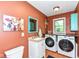 This laundry room includes a modern washer, dryer, and colorful decorative accents at 6580 Kings Ct, Avon, IN 46123