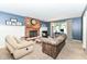 Spacious living room featuring a brick fireplace, blue walls, and an oversized sofa and recliner at 6580 Kings Ct, Avon, IN 46123