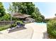 Backyard pool area with lounge chairs, a shade umbrella, and an adjacent pool house, perfect for relaxation at 6580 Kings Ct, Avon, IN 46123