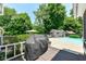 Outdoor deck with a grill overlooks the backyard pool, complemented by lush greenery and a pool house at 6580 Kings Ct, Avon, IN 46123