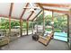 Relaxing sunroom features exposed beams, a swing, and backyard views of the pool and greenery at 6580 Kings Ct, Avon, IN 46123