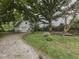 Backyard with gravel driveway, garage, deck, and a mature tree at 70 Fairground St, Franklin, IN 46131