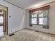 An empty room features paneled walls, carpet, and a large window at 70 Fairground St, Franklin, IN 46131