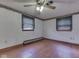 Bedroom featuring hardwood flooring, two windows, and a wall heater at 70 Fairground St, Franklin, IN 46131