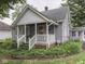 View of the front of a quaint cottage-style home with a cozy porch and lush garden at 70 Fairground St, Franklin, IN 46131