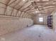 The unfinished upper-level of the garage includes plywood walls and ceilings with exposed trusses at 70 Fairground St, Franklin, IN 46131