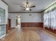 Hardwood living room showing connecting rooms, wood-paneled walls, and white lace curtains at 70 Fairground St, Franklin, IN 46131