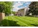Spacious backyard showcasing a lush lawn, wooden fence, and mature trees creating a serene setting at 7402 Northfield Blvd, Fishers, IN 46038