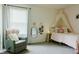 Comfortable bedroom with a cozy rocking chair, pink accents, and natural light from a large window at 7402 Northfield Blvd, Fishers, IN 46038